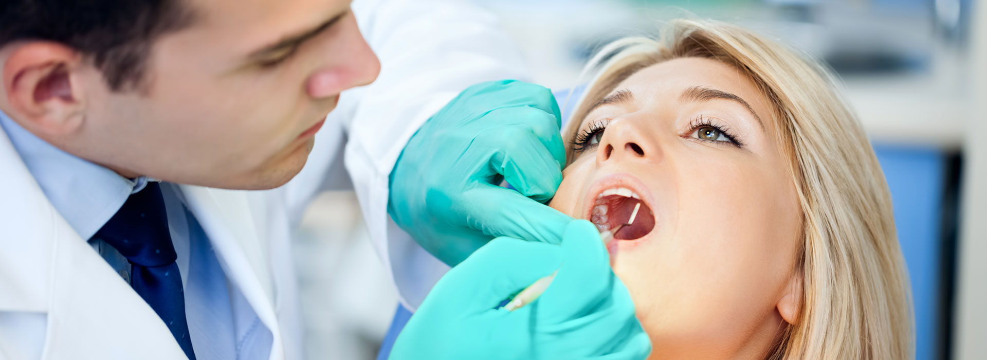 Dentist examining female patient's teeth